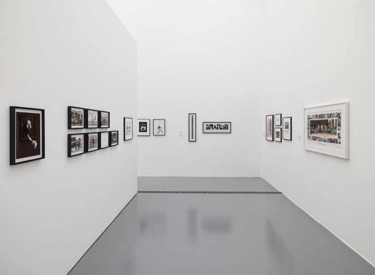 a very bright corridor with black and white photographs on all visible walls can be seen