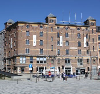 We see a brown brick building in the sunshine.