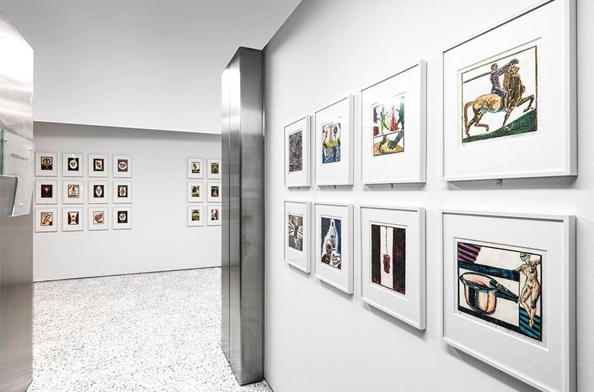 We look into the vertical gallery in the courtyard and see numerous small-format, colorful works of art.