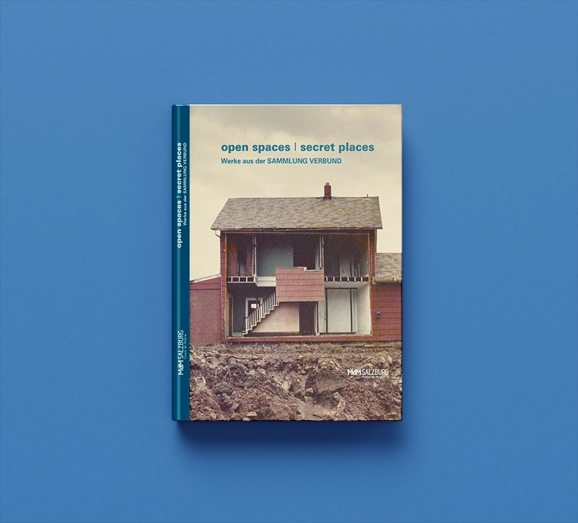 We see the exhibition catalog of open spaces / secret places from 2012. The cover shows direct insights into a single-family home. A side wall was removed so that the viewer can see into the interior of the house.