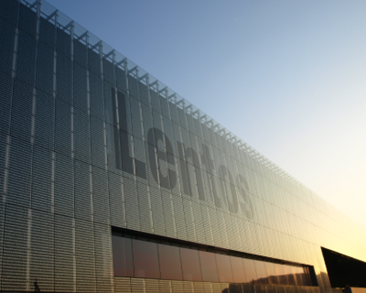 A view of the façade of the Lentos. The sun is low. The right part of the picture is illuminated in gold.